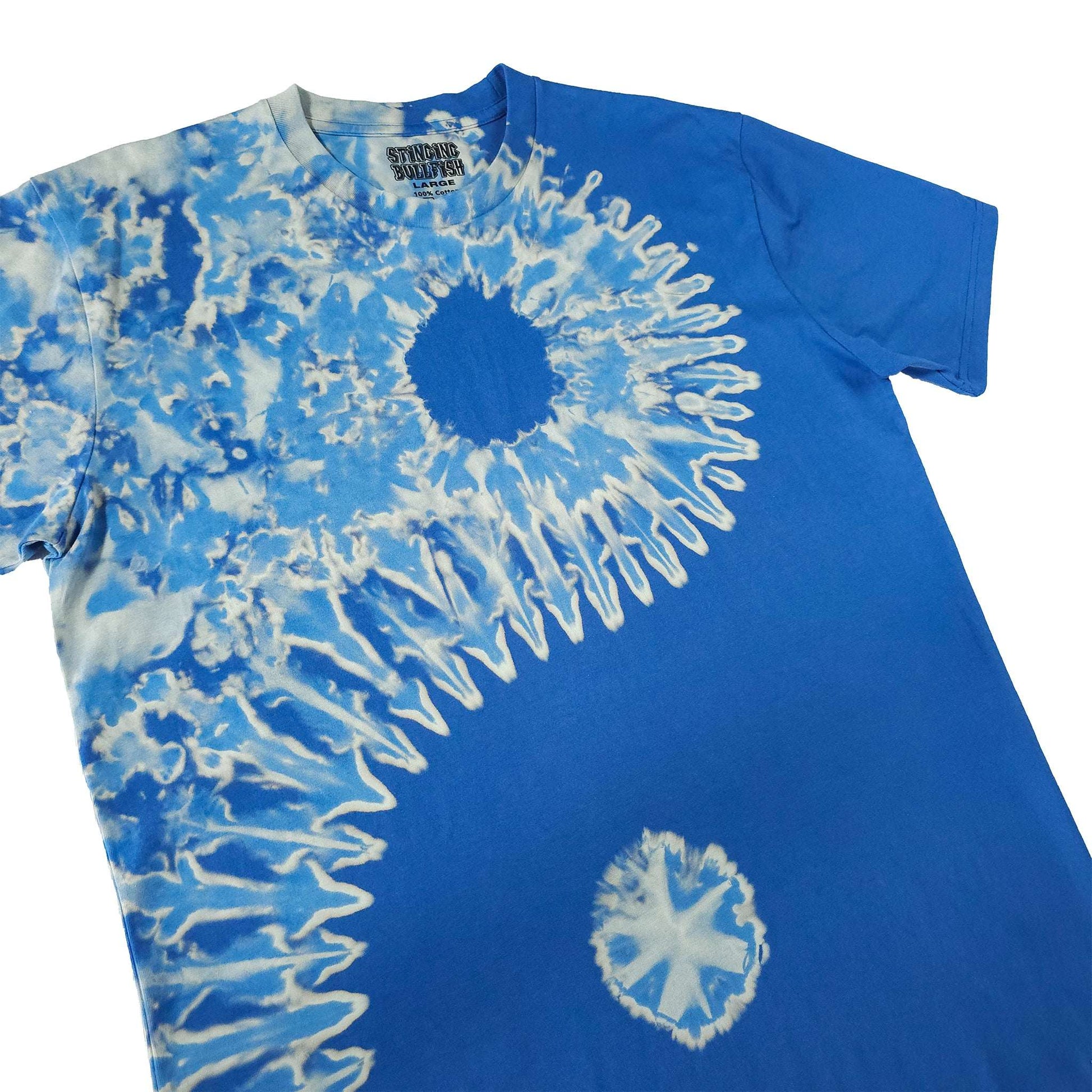 Blue bleach-dye T-shirt with dark center sunburst and white ring accents on chest