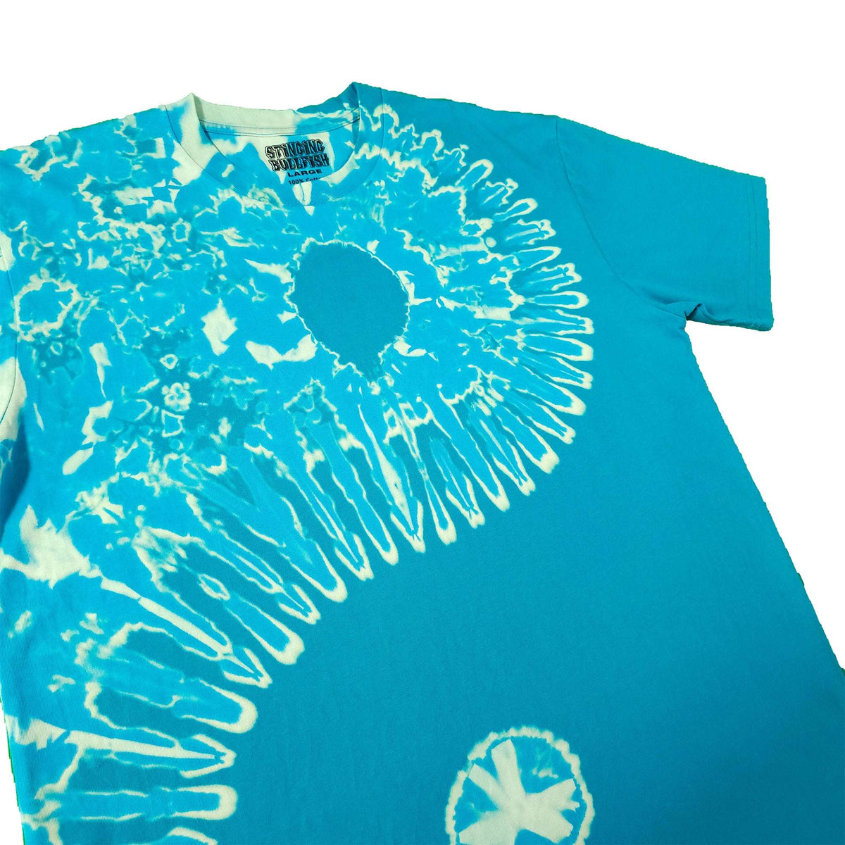 Teal tie-dye T-shirt close-up with white spiral burst and circular emblem