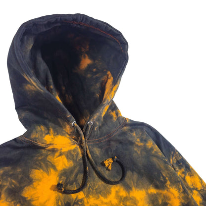 Close-up zip-front tie-dye hoodie with black drawstrings and bright orange-and-black pattern
