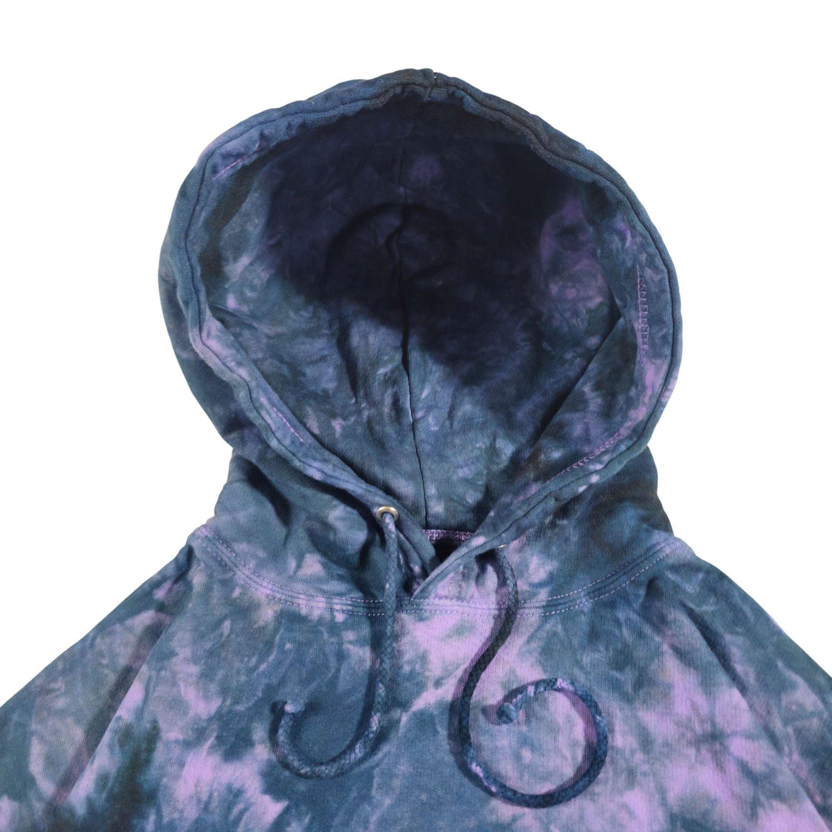 Tie-dye hoodie close-up: lined hood with dark drawstrings and stitched seams