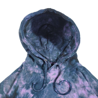 Tie-dye hoodie close-up: lined hood with dark drawstrings and stitched seams
