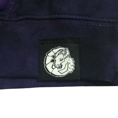 Woven logo patch on deep purple-and-black tie-dye hoodie front pocket area