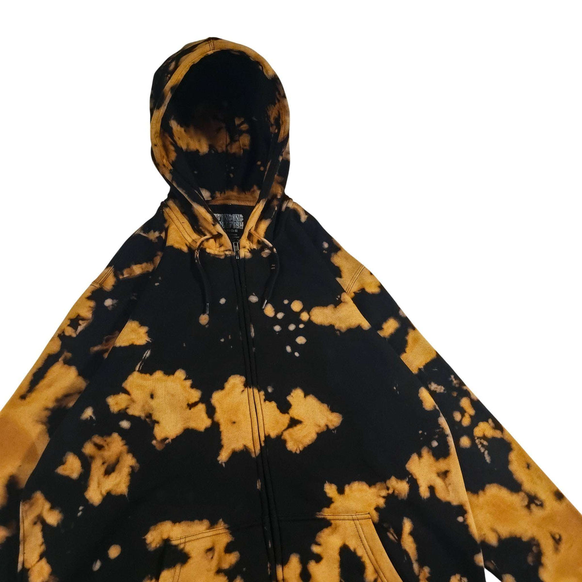 Black zip hoodie with tan/gold tie-dye splashes; adjustable hood with drawstrings