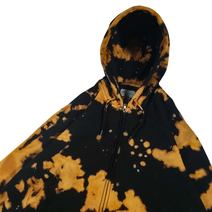 Bleach-dyed black zip hoodie with tan/gold cloud-like spots; hood and front zipper