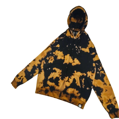 Bleach-dyed zip hoodie in black with tan/gold abstract pattern; hood and drawstrings