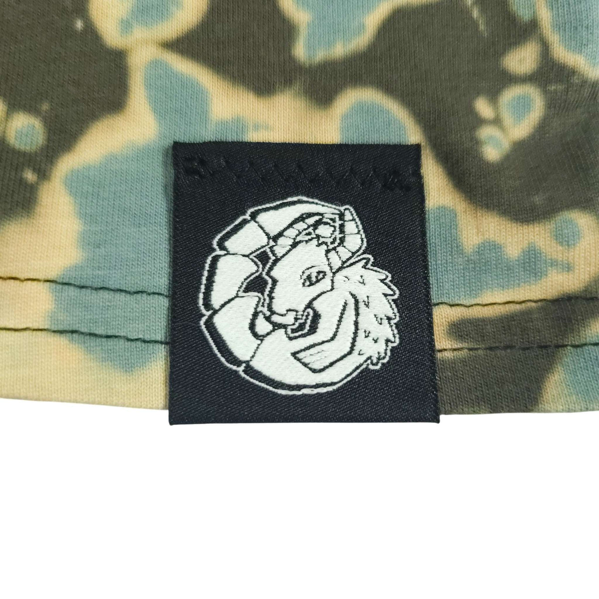 Clothing label patch on tie-dye crop top with dark green and teal pattern