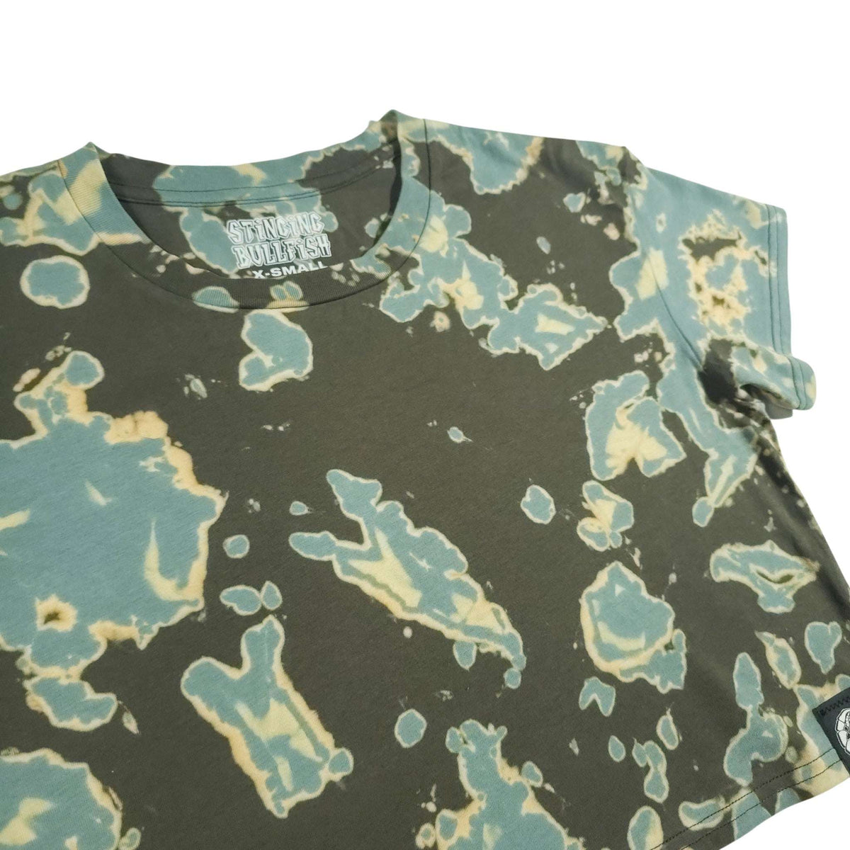 Tie-dye crop top with dark green base and teal and cream irregular paint-like splashes