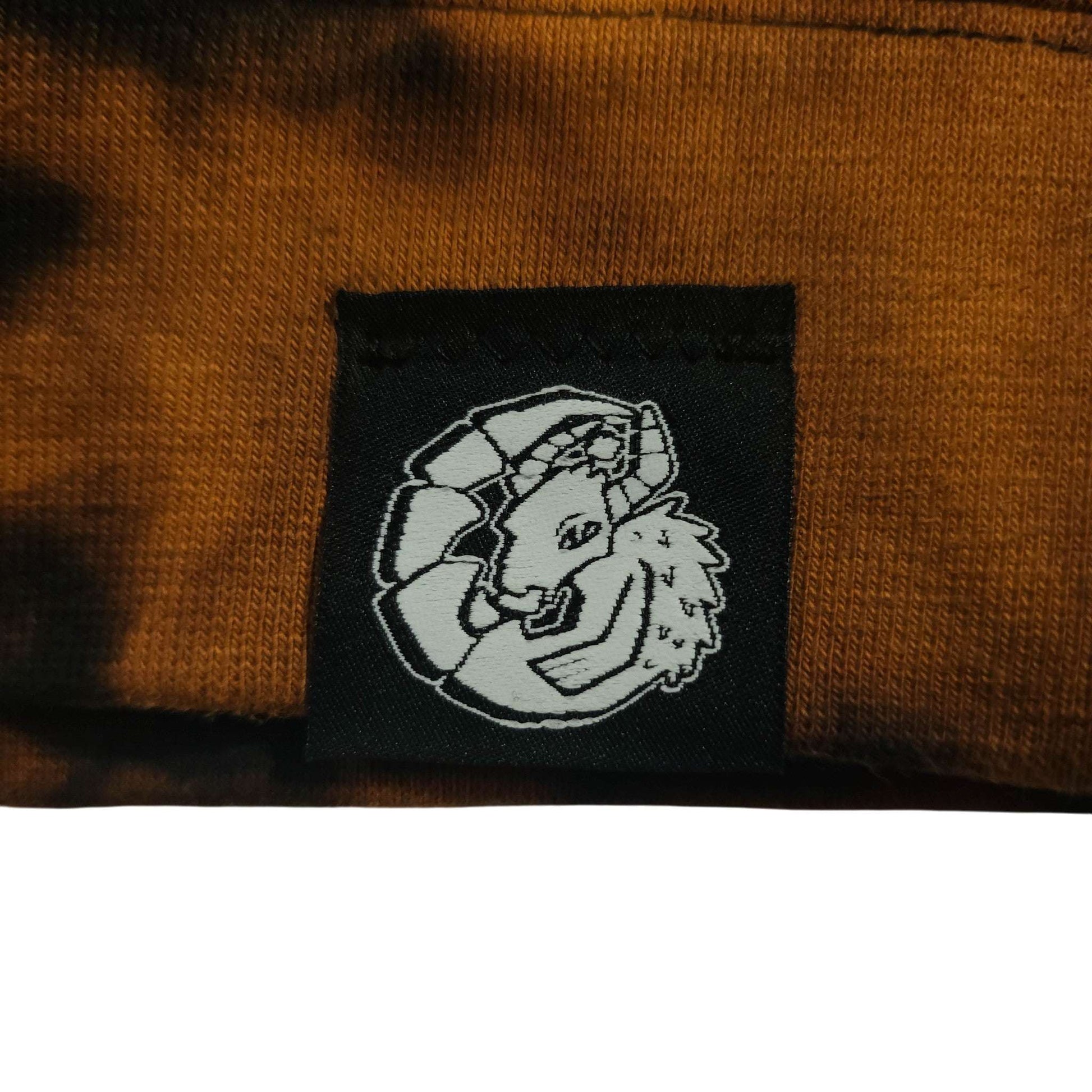 Logo patch on tie-dye hoodie, black embroidered icon on brown fabric