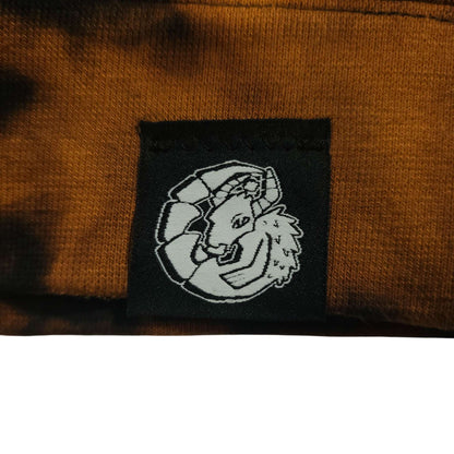 Logo patch on tie-dye hoodie, black embroidered icon on brown fabric