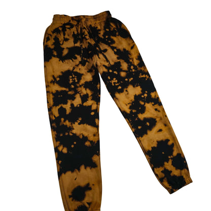Tie-dye jogging bottoms with elastic waist and drawstring; tan and black splatter front view.