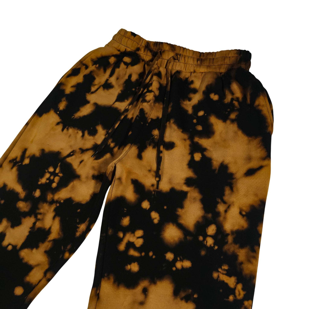 Tie-dye jogging bottoms close-up of waistband and drawstring; tan and black splatter.