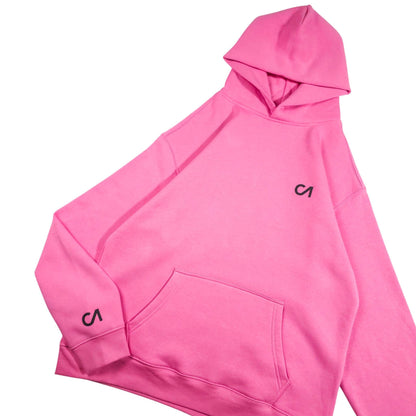 Pink pullover hoodie with hood and kangaroo pocket, front view with black logo