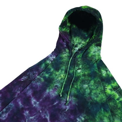 Green and purple tie-dye pullover hoodie with drawstring hood and angled front view
