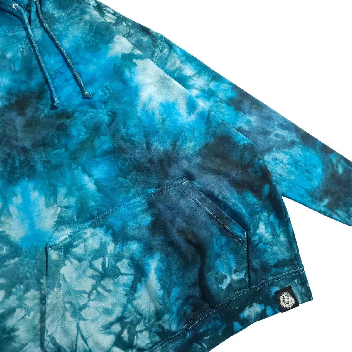 Tie-dye hoodie front with kangaroo pocket, sleeve cuff, and logo patch at hem