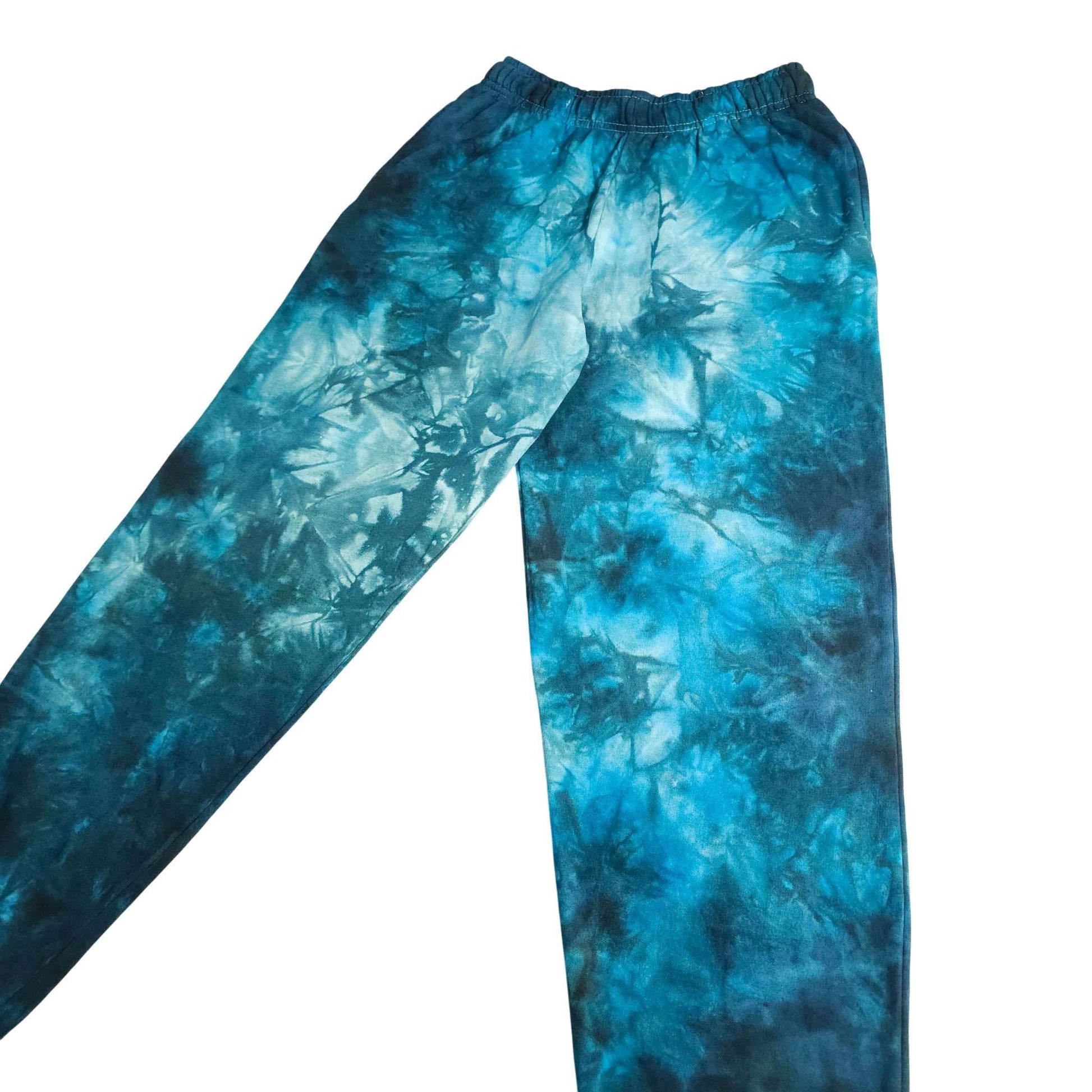 Blue tie-dye jogging bottoms, angled view showing relaxed legs and waistband