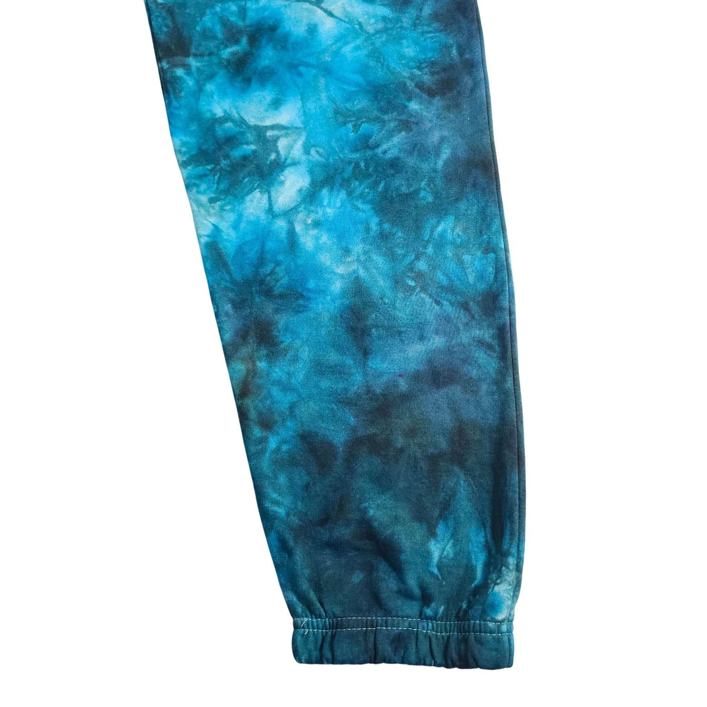 Blue tie-dye jogging bottoms, close-up of lower leg and ribbed ankle cuff