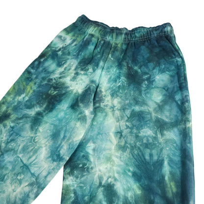 Teal and green tie-dye joggers, elastic waistband and tapered legs front view.