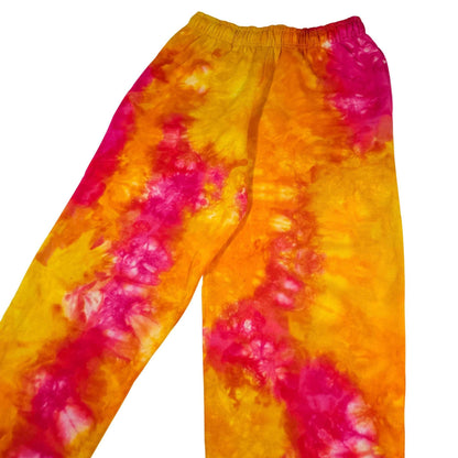 Orange and magenta tie-dye jogger pants with elastic waist and tapered fit