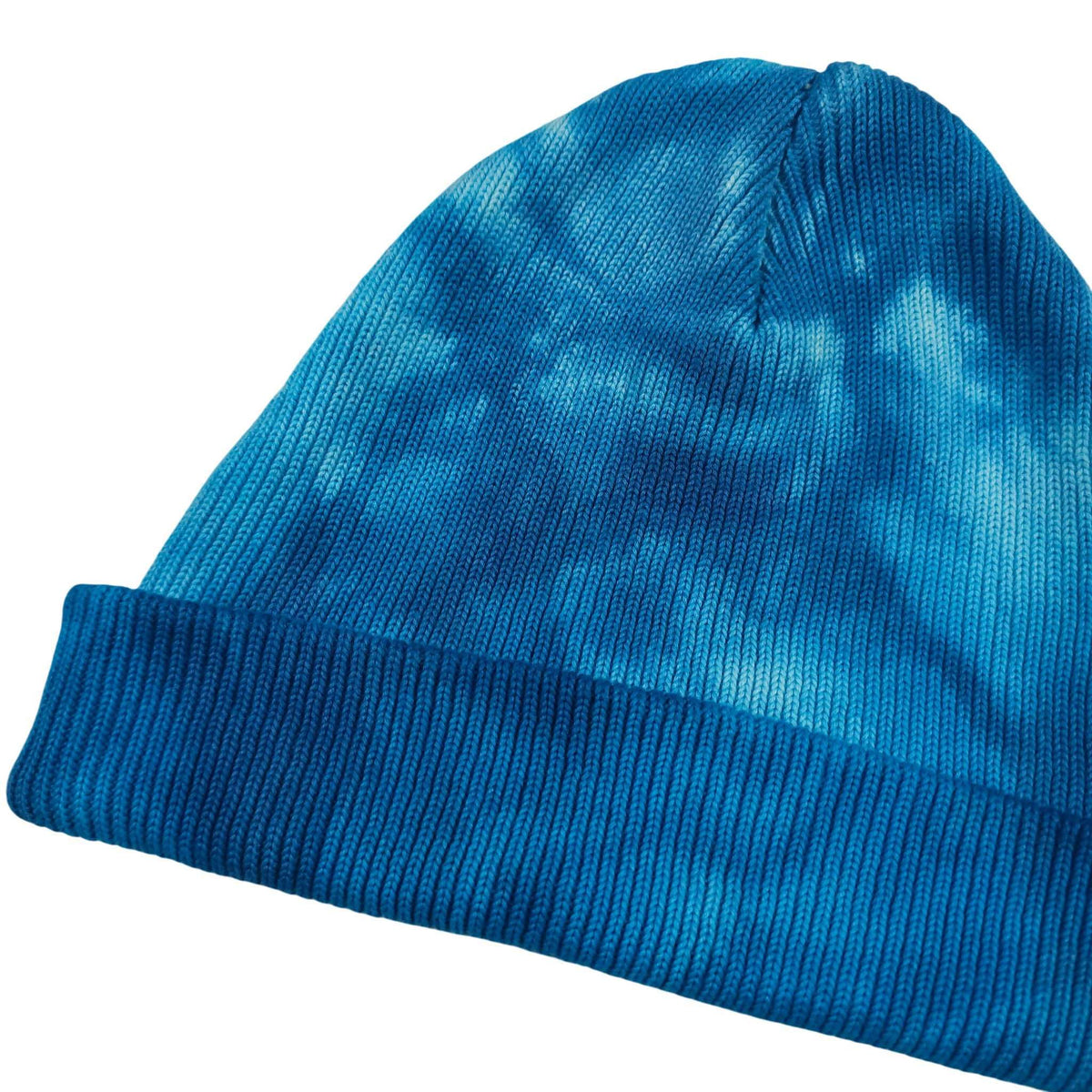 Blue tie-dye knit beanie with ribbed cuff, slanted side profile