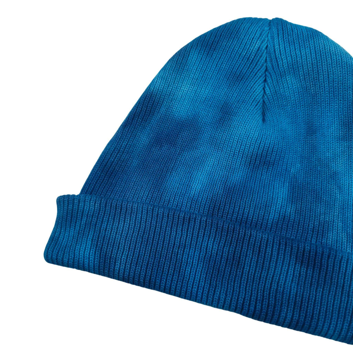 Blue tie-dye knit beanie hat with ribbed cuff and domed crown crease