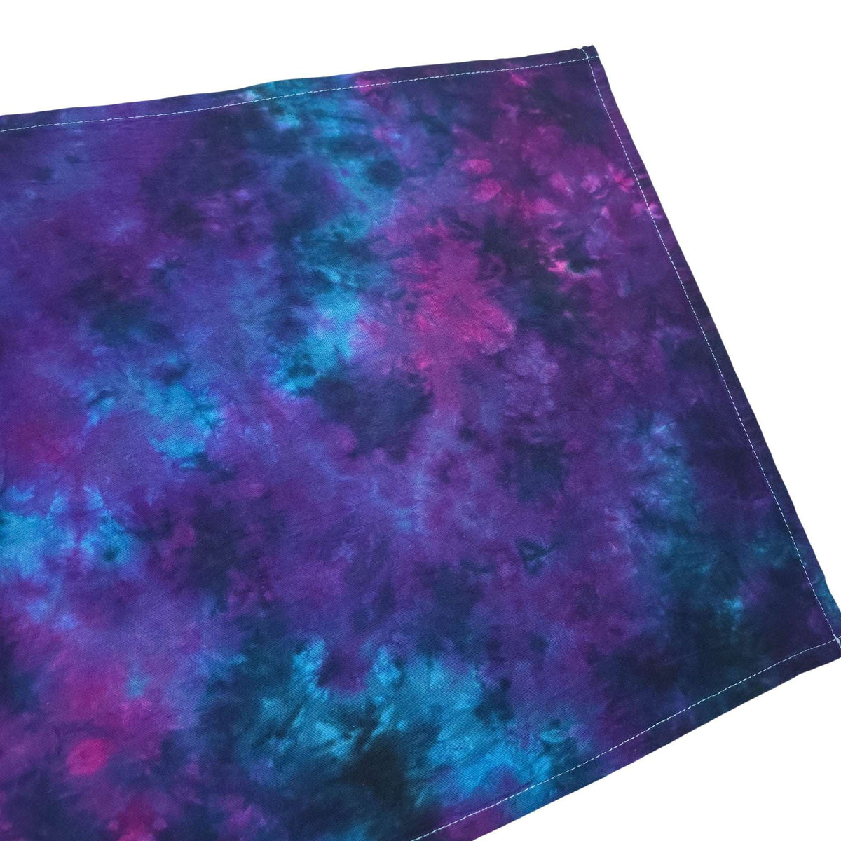 Nebula tie-dye tea towel close-up, purple-and-blue abstract pattern with stitched border