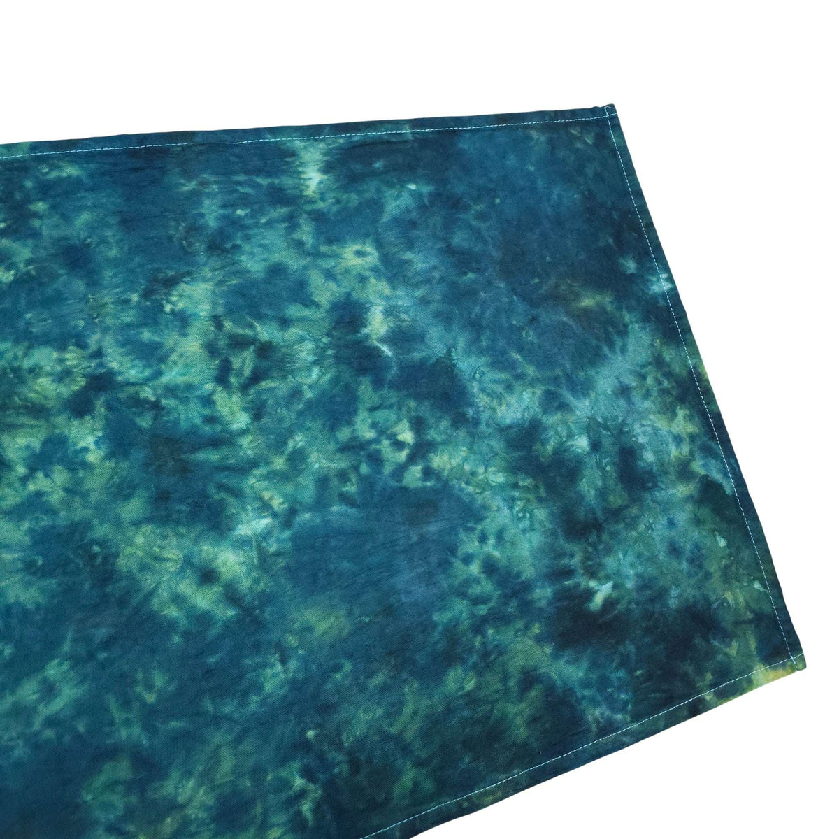 Teal and green tie-dye tea towel corner with stitched hem detail