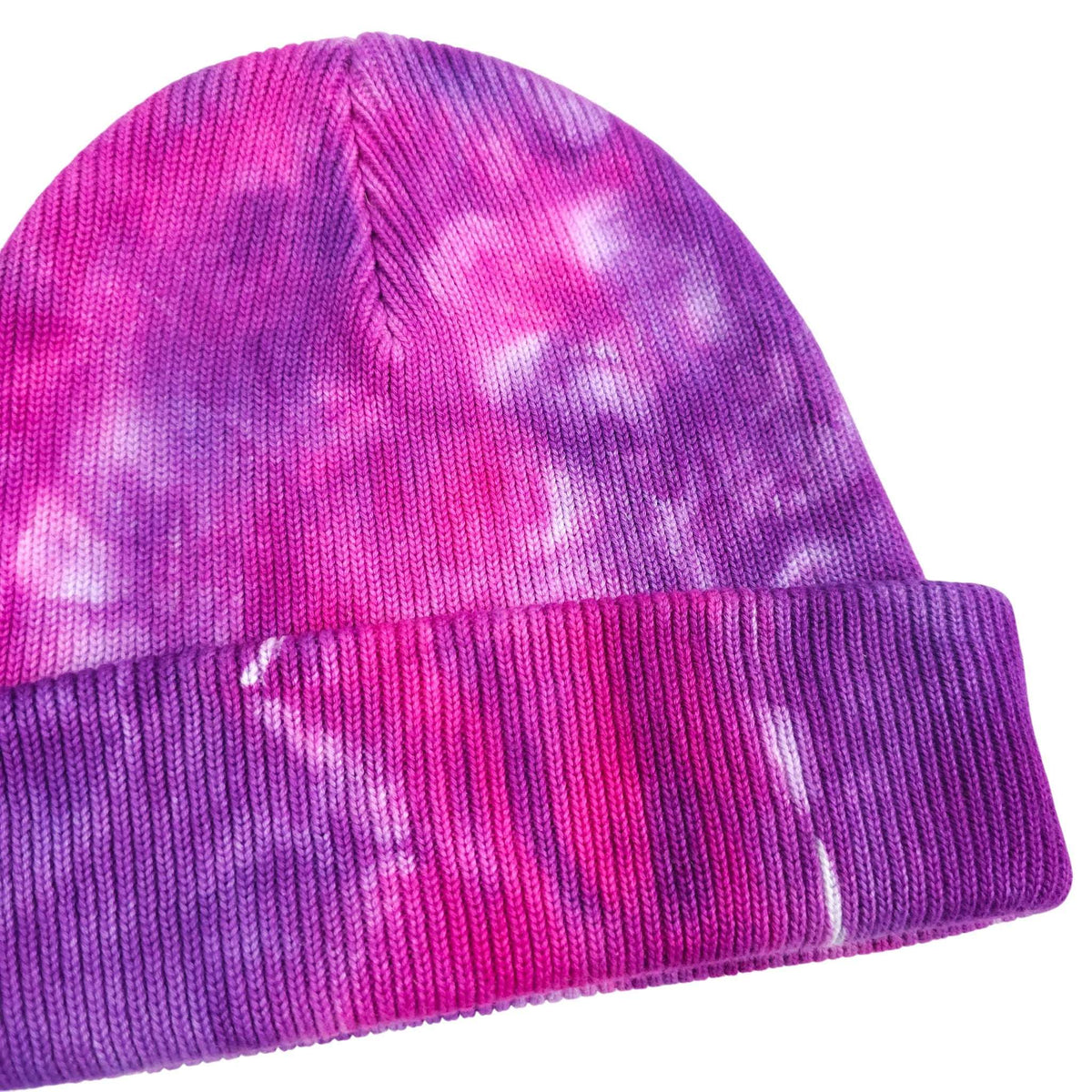 Tie-dye knit beanie with ribbed cuff, visible seam and folded edge in pink and purple