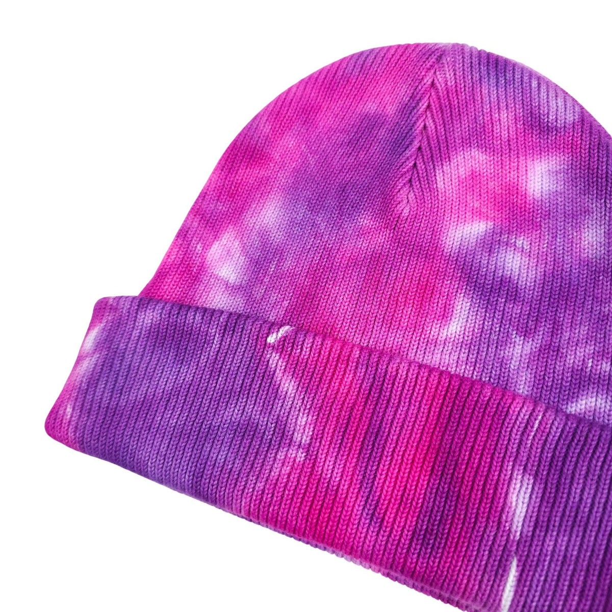Pink and purple tie-dye beanie with ribbed cuff and stitched knit texture, side view