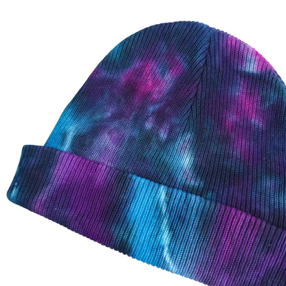 Nebula tie-dye beanie hat showing diagonal color streaks in blue and purple