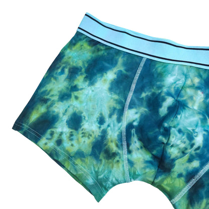 Blue-green tie-dye boxer briefs, angled front view with elastic waistband