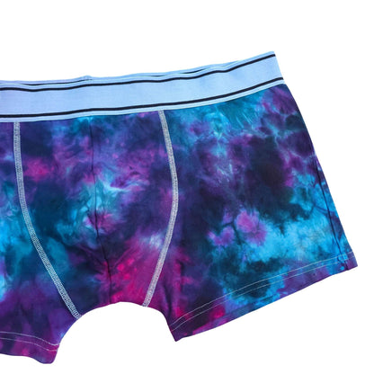 Men's tie-dye boxer briefs close-up: blue and purple nebula print, contrast stitching.