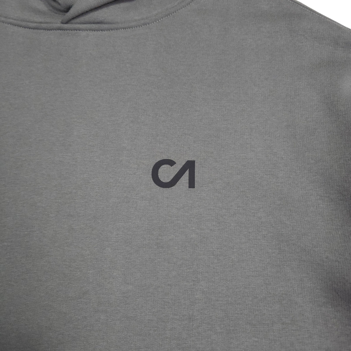 Grey hoodie fabric close-up with small chest logo