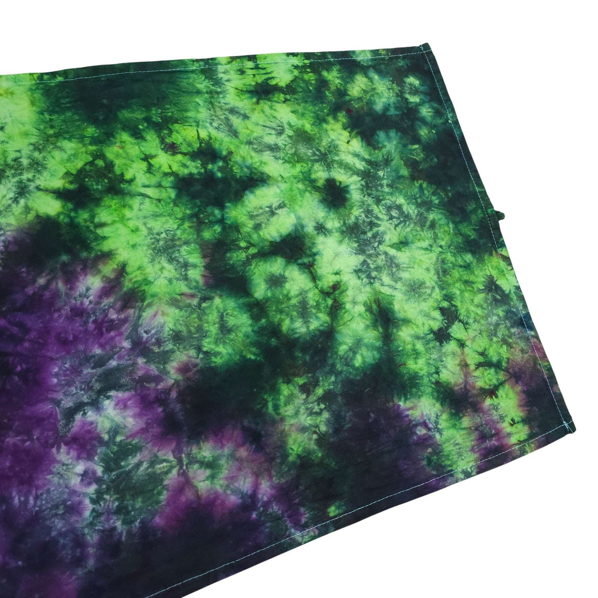 Folded tie-dye tea towel with green and purple mottled pattern and dark edge stitching