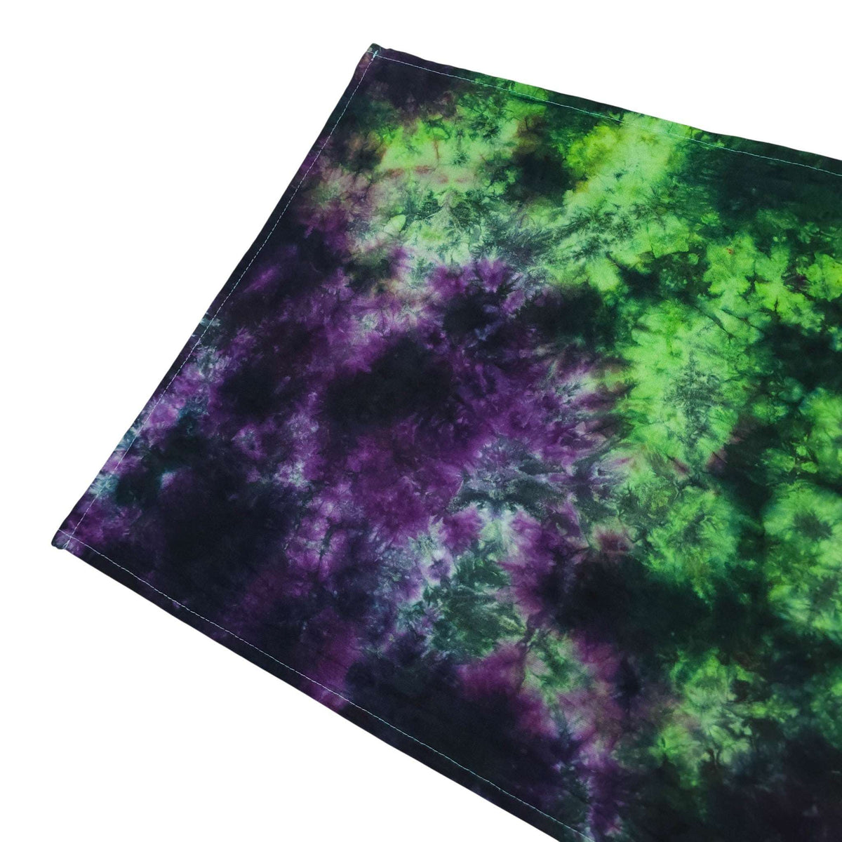 Rolled tie-dye tea towel in green and purple with dark stitched border
