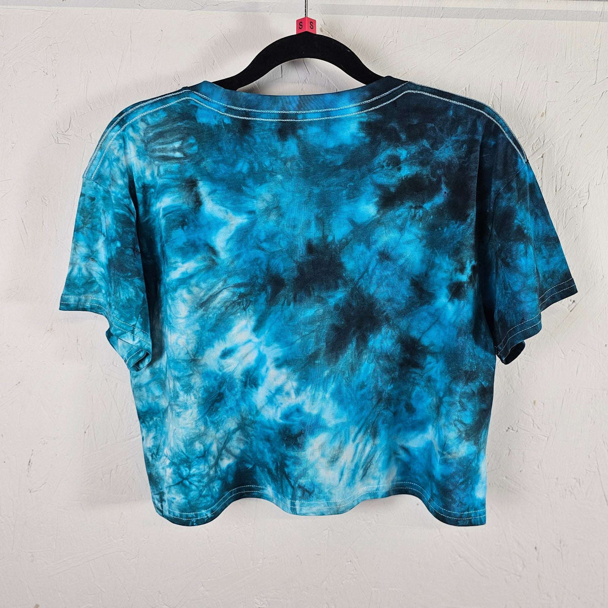 Back view of blue tie-dye crop top with short sleeves