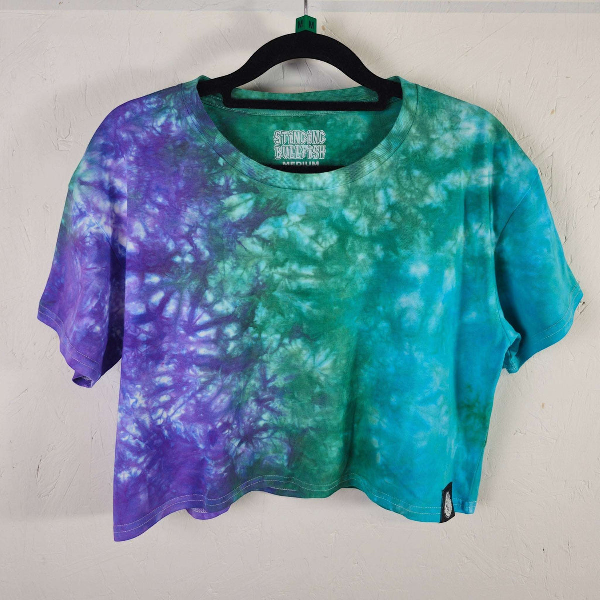 Tie-dye crop top with teal, green, and purple swirl pattern; short sleeves, crew neck.