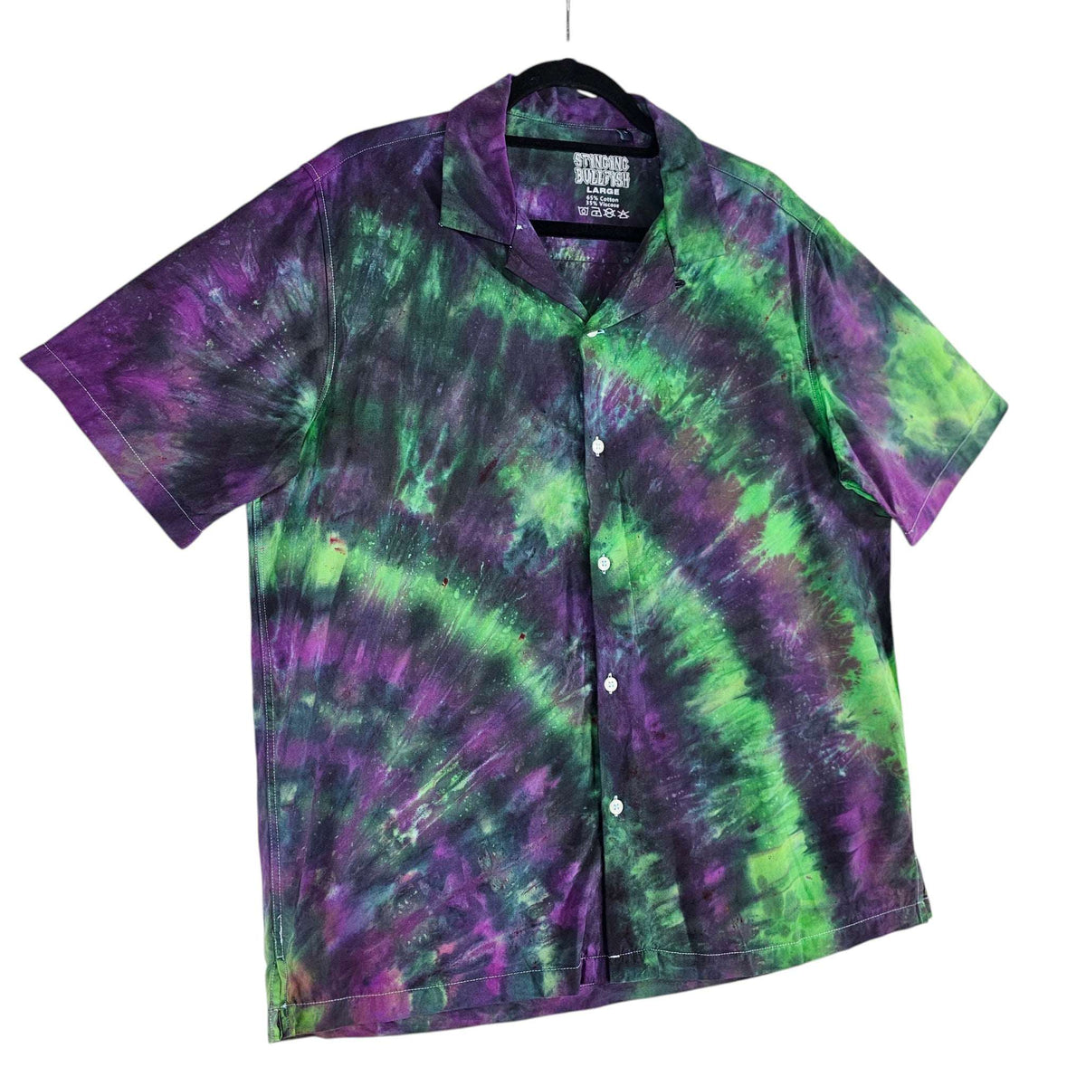 Tie-dye short-sleeve button-up shirt featuring purple and green swirl stripe pattern